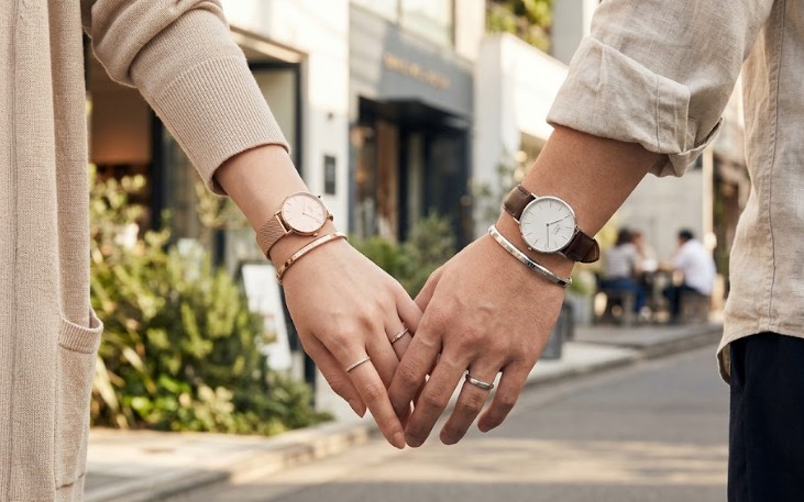 東京の代官山を散策するアジア人カップル。手元には、ダニエルウェリントンのローズゴールドとシルバーの時計に加え、それぞれのカラーに合わせたバングルとリングが上品に重ね付けされており、ブランドの世界観を体現している