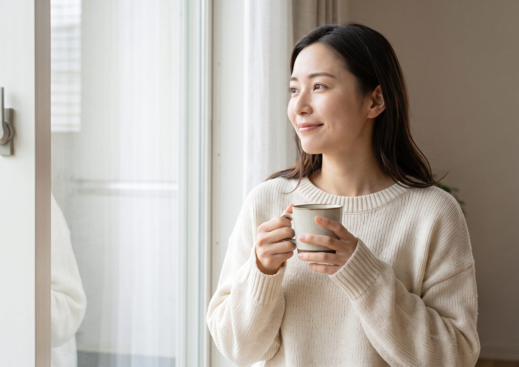 休日の朝、窓辺でリラックスする、すっぴん風メイクの日本人女性