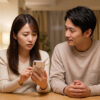 スマホで婚約指輪について検索しながら、少し不安げな表情を浮かべる、日本人のカップル。東京の夜の自宅にて